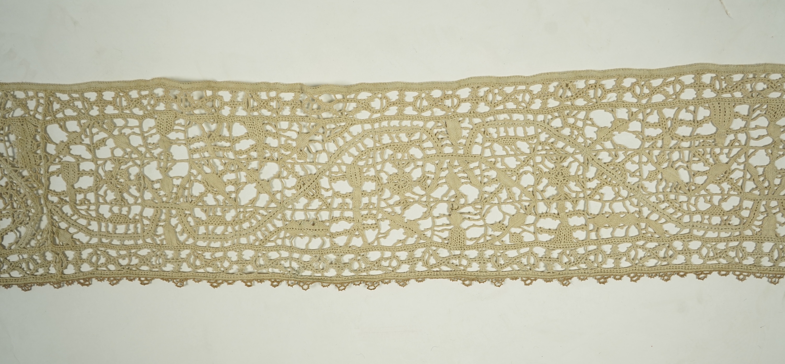 A length of late 16th early 17th century Venetian Reticella needle lace. Possibly cut from a wider panel or the edge to an Ecclesiastical robe or a furnishing lace. Designed with figures, worked in button hole stitch. 17
